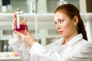 Lab worker holding vial with red liquid 